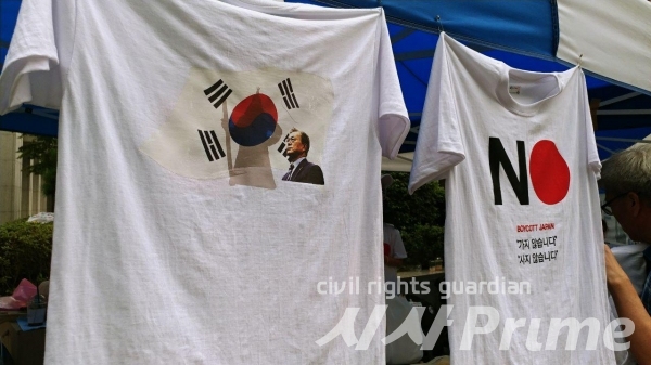 3일 아베 규탄 촛불 문화제가 열린 가운데 '일본에 가지 않는다', '사지 않는다' 문구가 새겨진 티셔츠와 태극기에 문재인 대통령과 이순신 장군이 새겨진 티셔츠.  [사진 / 박선진 기자]