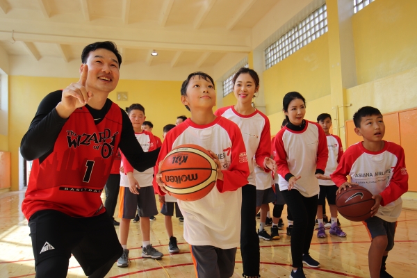 아시아나항공(사장 한창수)가 18일(수) 몽골 울란바타르 성긴하이르항구에 위치한 83번 초등학교에서 '제1회 몽골-아름다운 교실'을 실시했다. 행사에 참석한 아시아나항공 직원들이 83번초등학교 학생들과 함께 체육관에서 농구 연습을 하고 있다. ⓒ아시아나항공