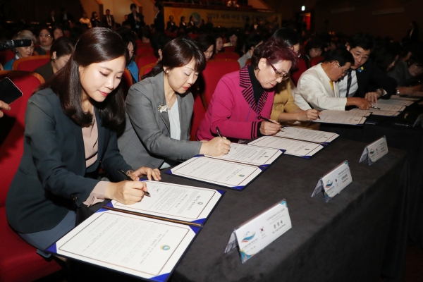 2019 세계 여성 평화 콘퍼런스에서 참가자들이 세계여성 평화서약서 및 한반도 평화통일 지지서명서에 서명하고 있다.