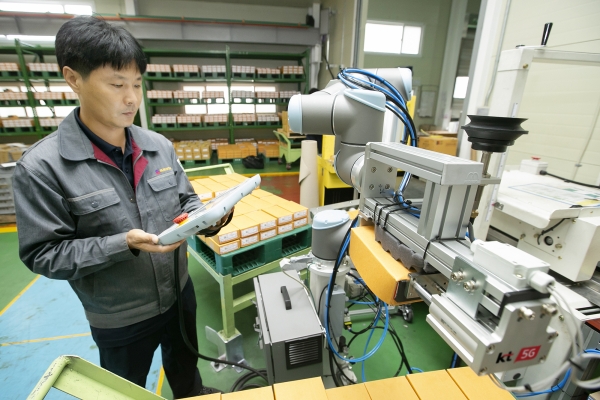 충북 제천에 있는 박원 공장에서 생산직 근로자가 KT 5G 스마트팩토리 코봇과 함께 작업하고 있다.  ⓒKT