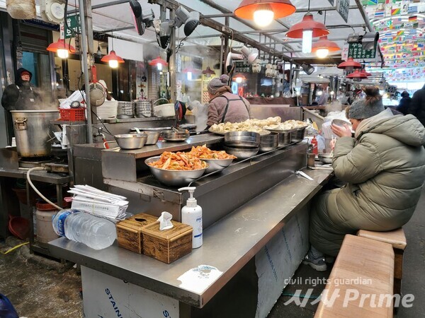 23. 01. 24. 한 외국인 관광객이 따뜻한 만두국을 먹고 있다. [사진=김용철 기자]